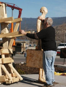 Artist Michael Hermesh removing frank the baggage handler from the Penticton Roundabout after being vandalised.