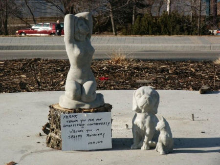 Scuptures left at the Penticton roundabout where Frank once stood.   Sign reads: Thankyou for a interesting controversy wishing you a speedy recovery. 