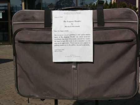 Due to recent acts of vandelism to the central human figure of The Baggage Handler the entire scupture installation has been temporarily removed for repairs.  We hope to have this work of are re-installed over the next six to eight weeks.  Please express your support for publicaly funded art to the gallery, city and local media.  ~Curtis Collins Curator of the Art Gallery of the South Okanagan